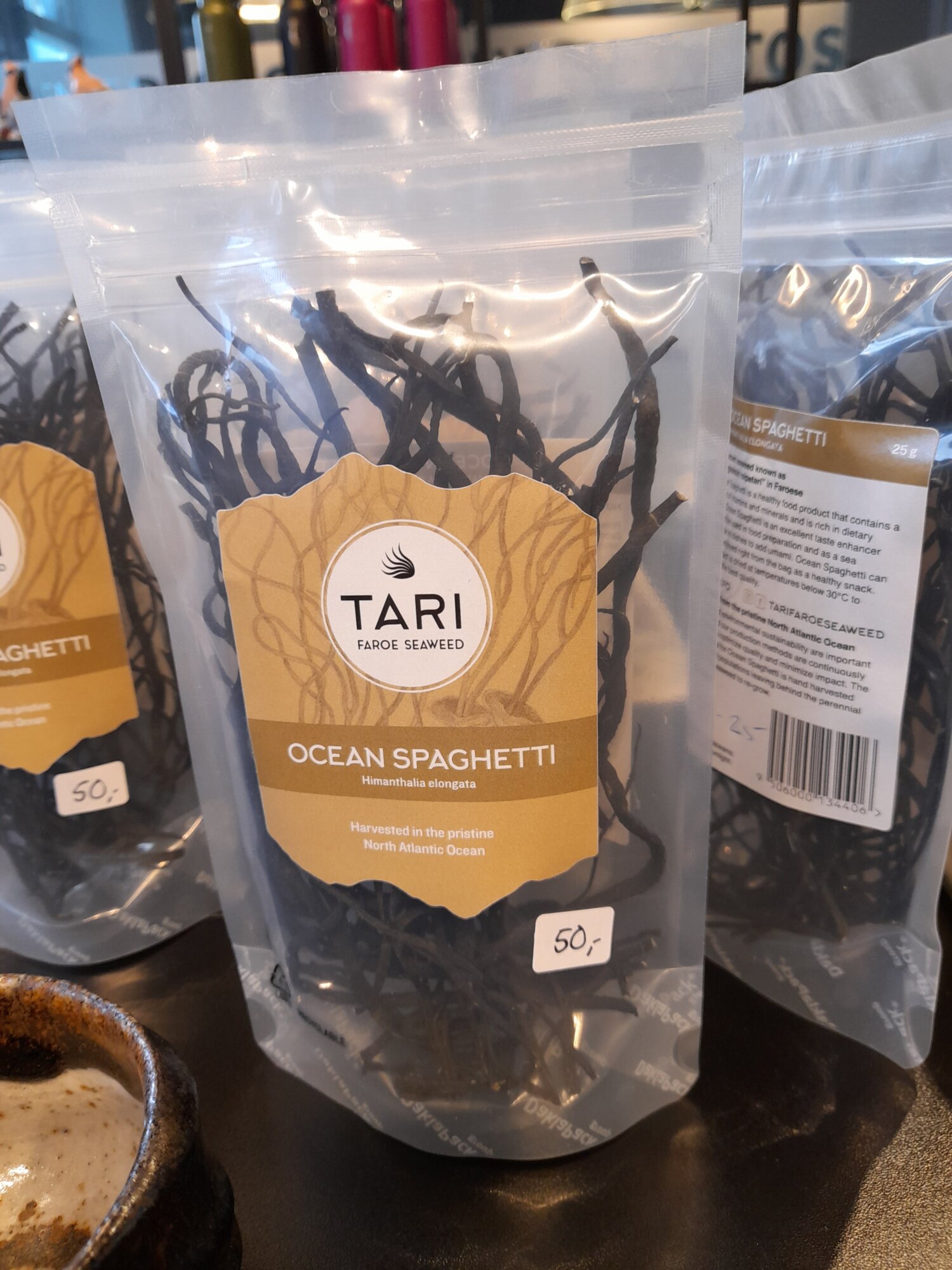 Przezroczyste opakowanie suszonych wodorostów „Ocean Spaghetti” marki Tari Faroe Seaweed stojące na półce sklepowej z etykietą ceny 50 DKK.