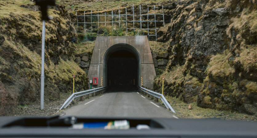 Wjazd do jednojezdniowego tunelu drogowego drążonego w skale na Wyspach Owczych widziany z wnętrza samochodu