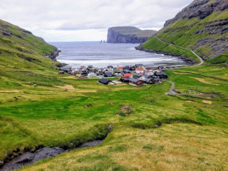 Widok na wioskę Tjørnuvík na Wyspach Owczych położoną w zielonej dolinie nad oceanem, popularny punkt podczas wycieczki objazdowej i wyjazdów na Wyspy Owcze